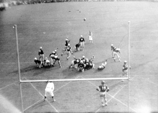 A black and white photo of men playing football.