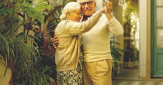 An older couple dancing in a courtyard, showcasing their enduring love.
