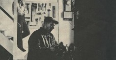 A black and white photo of two men in a room, showcasing the contrast between them.