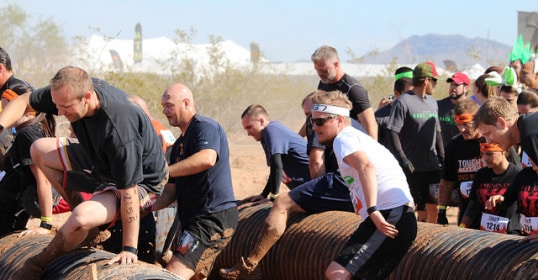 A group of Vermonter running through a Tough Mudder obstacle course.