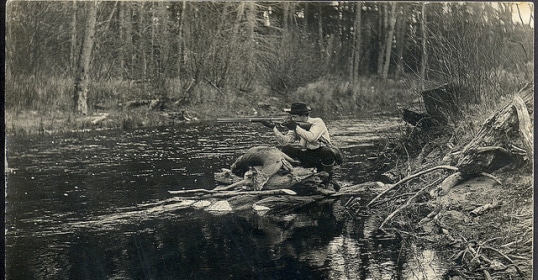 A man sitting on a log in a river, keywords unchanged.