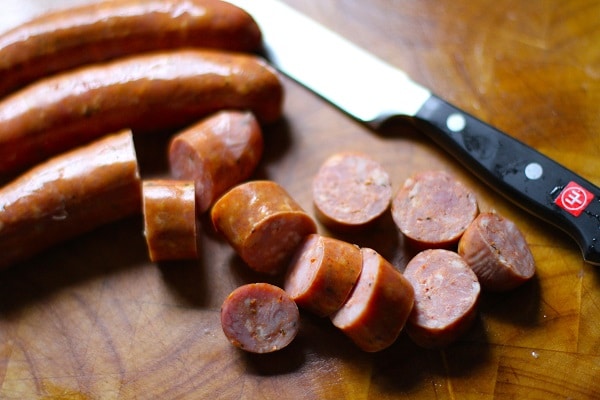 Andouille sausage with knife on table.