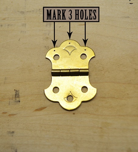 Mark three holes in the tailpiece of guitar.