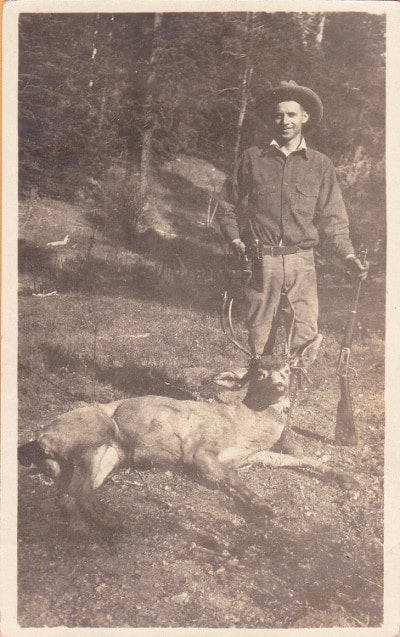 vintage hunter posing with deer kill 