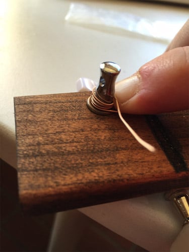 Man pointed a wire turner on cigar box.