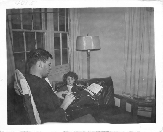 Vintage man in living room writing on typewriter. 