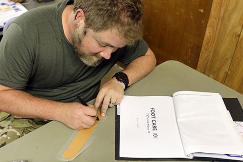 Brian Green writing a short note on foot care.