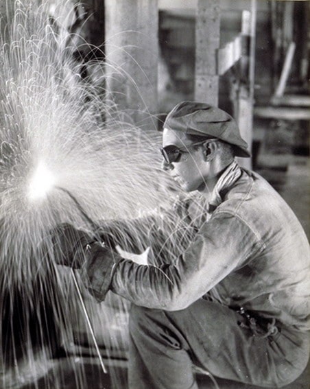Vintage welder working in factory sparks flying.