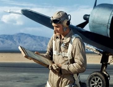 The man is checking a map in front of the airplane.