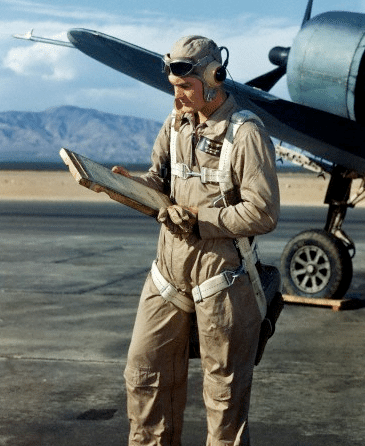 Vintage pilot outside Airplane looking at checklist.