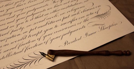 A calligraphy pen rests on a piece of paper, showcasing exquisite cursive penmanship.