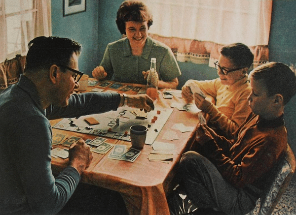 Vintage family playing board game at Table. 