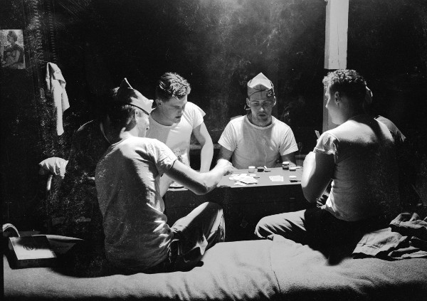 Vintage sailors playing poker in bunks. 