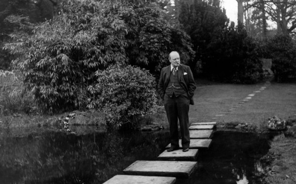 Winston Churchill taking walk walking across pond. 