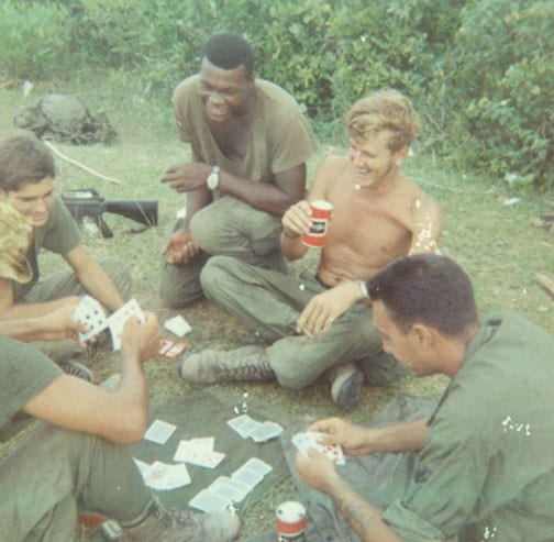 Vintage Vietnam soldiers playing cards in the Grass. 