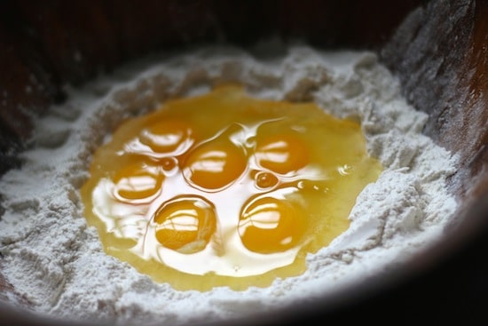 Cracked eggs in center of Flour well.