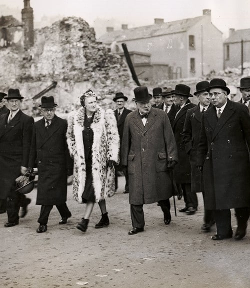 Winston and clementine Churchill touring war ruin with group of Men.