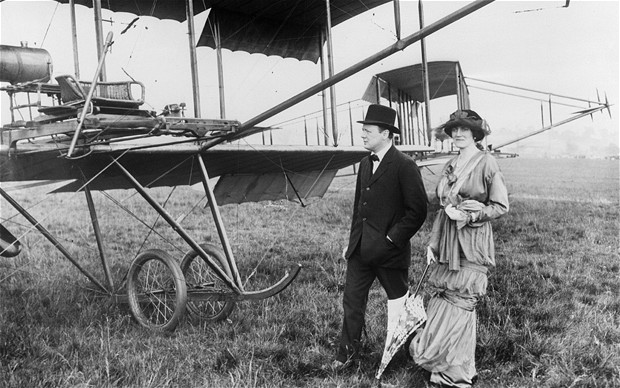 Winston and clementine Churchill standing next to Airplane. 