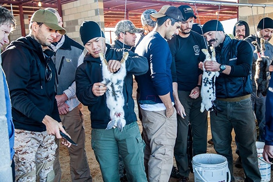 Men Gathered and Cleaning a Rabbit for eating.