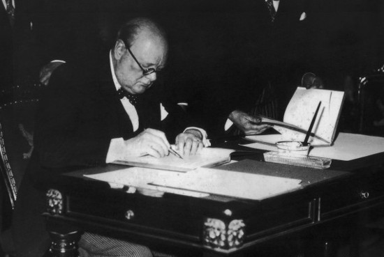 Churchill writing something on the paper.