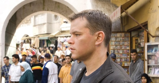 A man is standing in front of a crowd, displaying exceptional situational awareness.