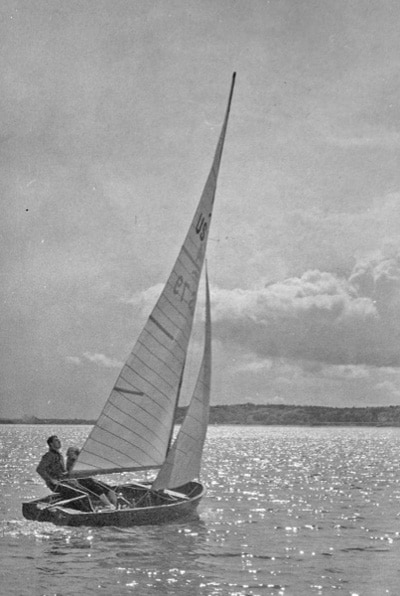 Vintage sail boat on lake in wind.