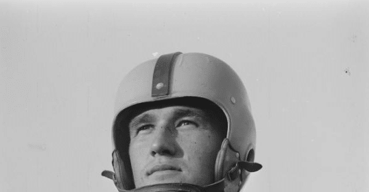 A black and white photo of a football player captures the essence of a manvotional moment on the field.