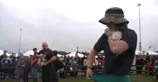 A man wearing a hat is dancing in front of a crowd.