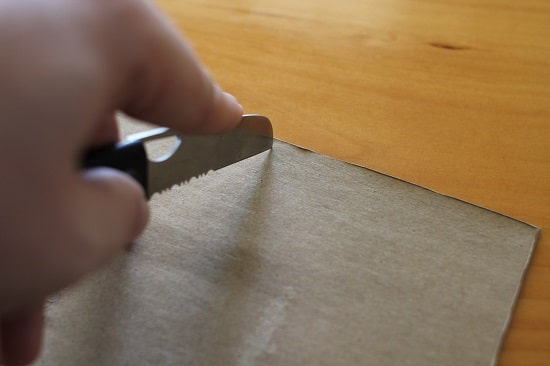 A man cutting the packet cover with knife.