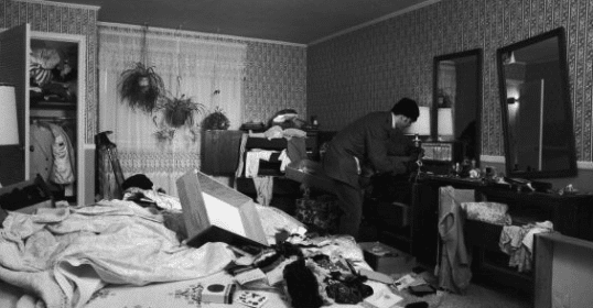 A black and white photo of a messy bedroom, showcasing the need for improved home security.