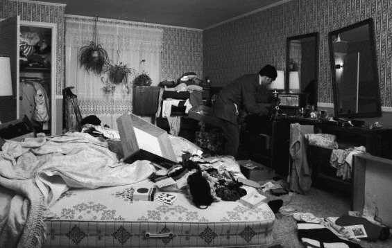 A black and white photo of a messy bedroom, showcasing the need for improved home security.