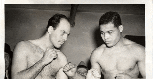 Two boxers standing in a black and white photo.