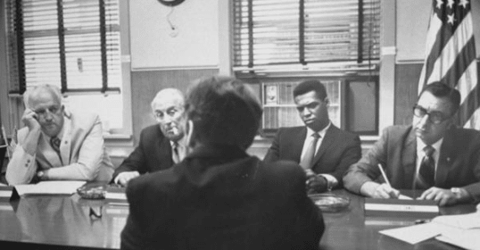 A group of men brainstorming around a conference table.