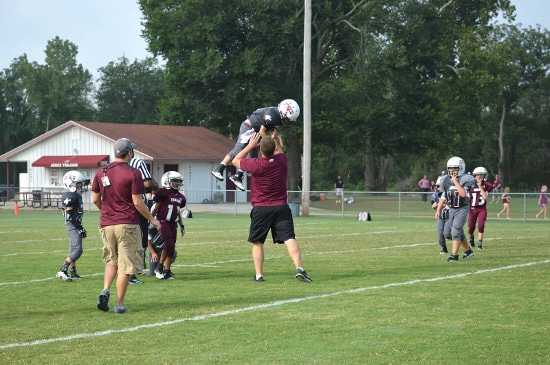 Coach and kids playing in ground.