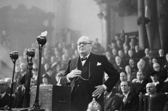 Winston churchill speaking giving speech at podium.