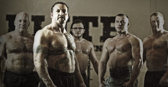 A group of men, including Chris Duffin, posing in front of a wall for a podcast.
