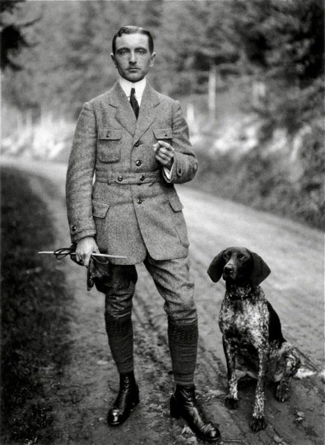 vintage hunter on road with pointer dog wearing sporting jacket