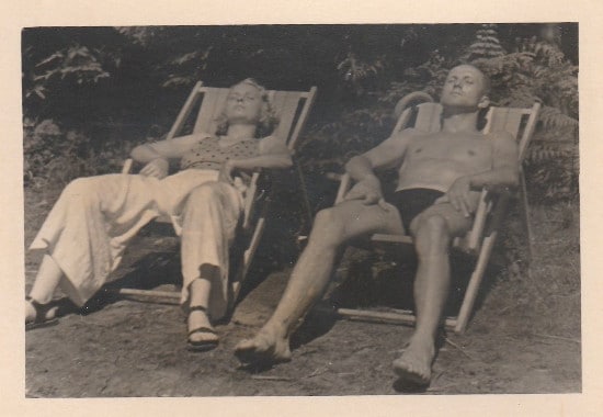 A couple sitting on sunbath chairs. 