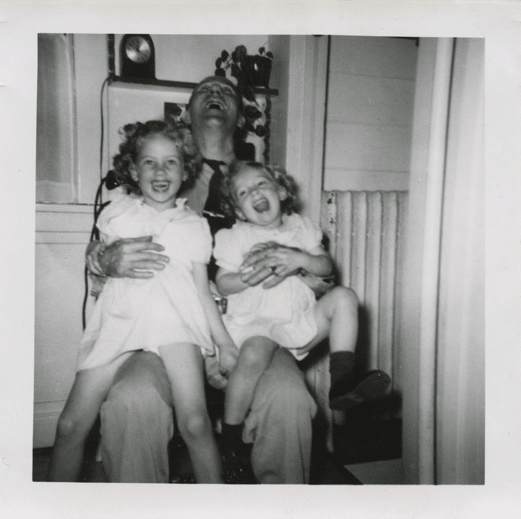 vintage father laughing with children daughters