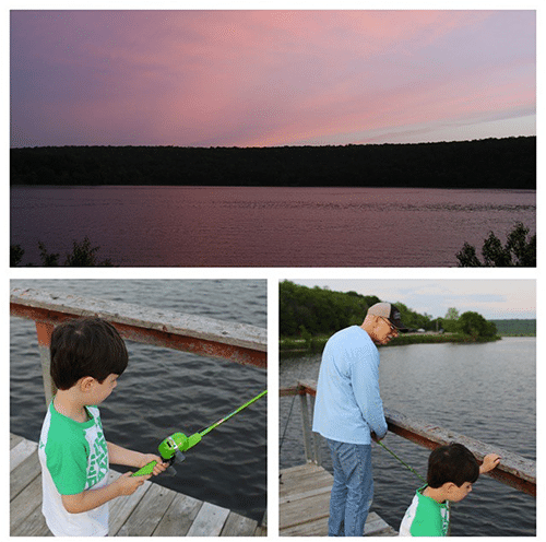 Young boy fishing with grandfather on lake with a fishing rod.