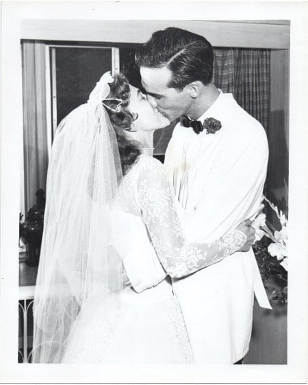 An old black and white photo of a bride and groom kissing, capturing the surprising moment.