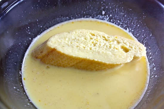 Dipping the french toast in the egg and milk mixture.