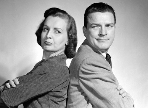 A black and white photo of a man and woman posing together.