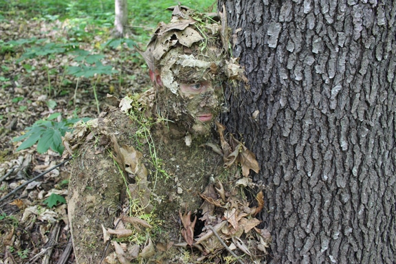 Man camouflaged with tree.