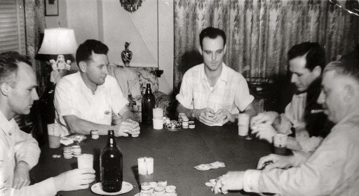 A group of men gathered around a table for Poker Night.