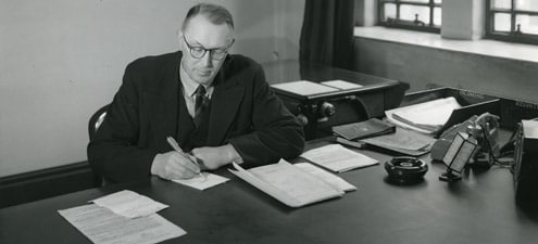 An emotional black and white photo of a man at a desk.