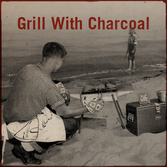 A man is grilling with charcoal.