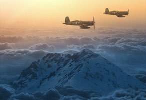 Two planes flying over the mountains at sunset.