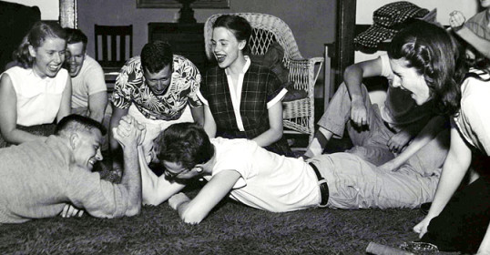 Black and white photo of a group of friends laying on the floor.