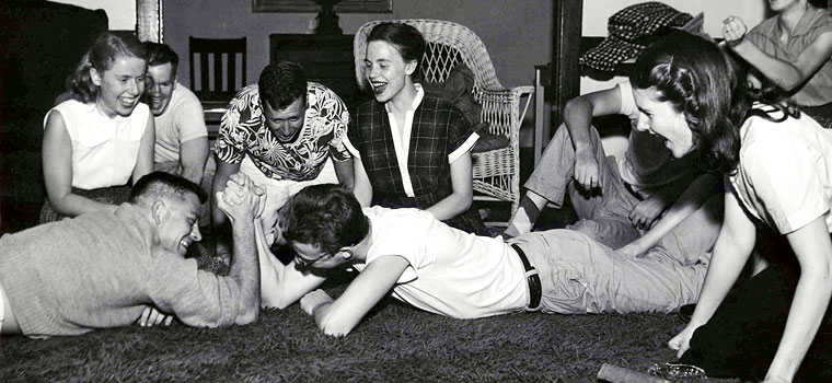 Black and white photo of a group of friends laying on the floor.